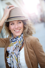 Wall Mural - Cheerful blond woman in town with hat on