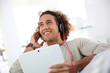 © goodluz - Smiling man listening to music with tablet