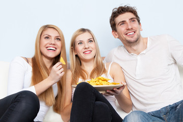 Group of young people eating pizza at home