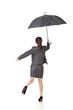 Asian business woman jumping with umbrella