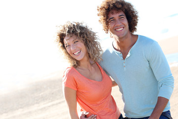 Wall Mural - Smiling couple walking on the beach