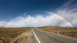 Beautiful full rainbow over road and mountain, New Zealand