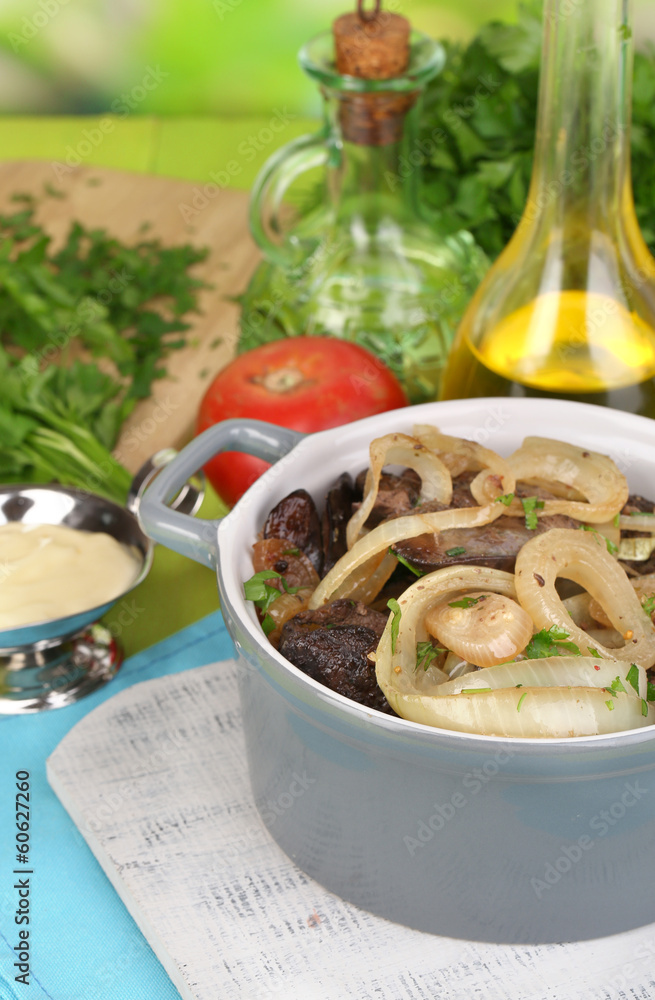 Fried chicken livers in pan on wooden table close-up