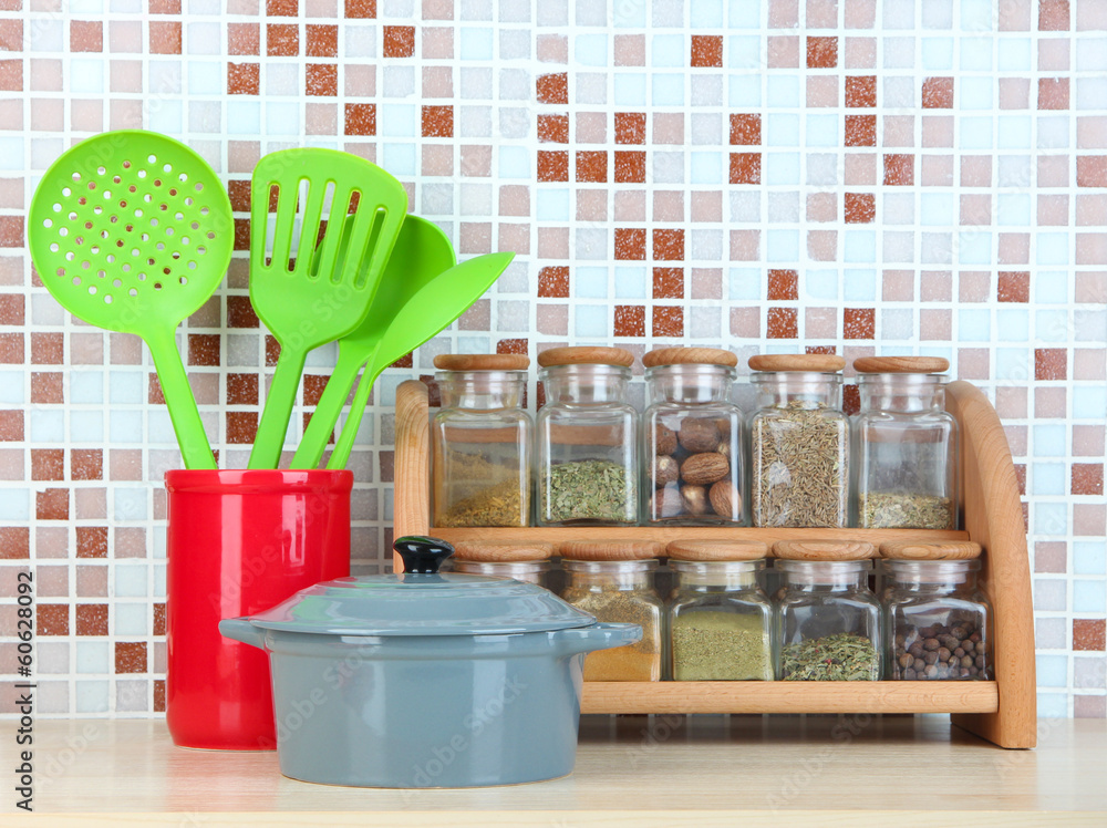 Set of spices, tableware and kitchen utensils in kitchen