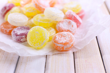 Wall Mural - Sweet  multicolor candies on paper, on  color wooden background