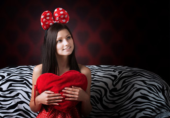 Funny girl with a heart cushion, hearts background