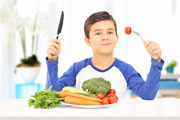 Young boy eating healthy meal seated at table