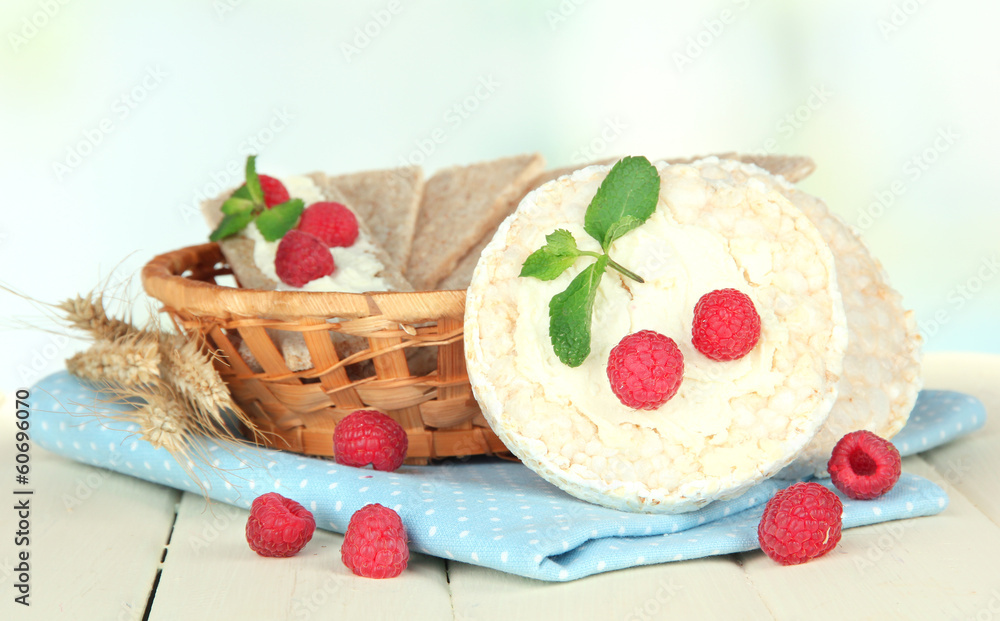Tasty crispbread with berries in wicker basket, on white table