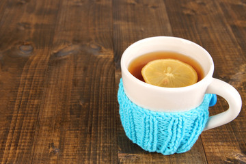 Fototapete - Cup of tea with lemon on wooden table