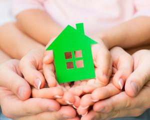 Wall Mural - Family holding green paper house