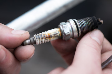 worn spark plug in male hand