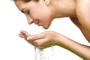 Beautiful woman refreshing her face with water