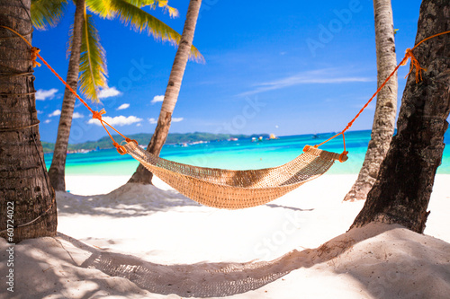 Obraz w ramie Słomiany hamak w cieniu palm na tropikalnej plaży