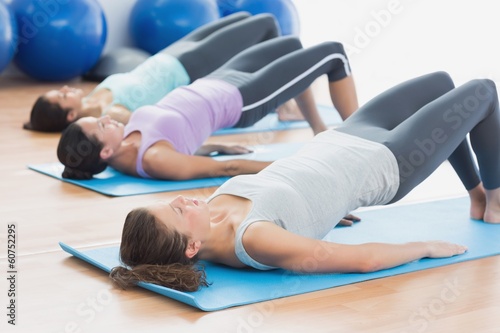 Girls doing Pilates at fitness studio. Fit class exercising at fitness studio