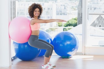 Sporty woman with exercise ball in fitness studio