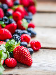 Wall Mural - Mix of berries on rustic wooden background