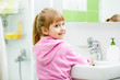 © Oksana Kuzmina - child girl washing her face and hands in bathroom