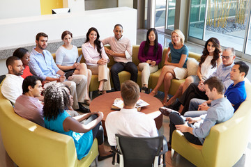 Multi-Cultural Office Staff Sitting Having Meeting Together