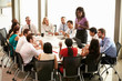 © Monkey Business - Businesswoman Addressing Meeting Around Boardroom Table