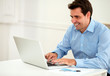 © pablocalvog - Attractive male entrepreneur working on his laptop