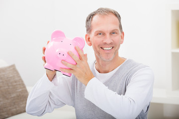 Wall Mural - Man Holding Piggybank