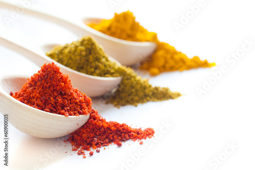 Fotografia Spices in wooden spoons on a white background closeup