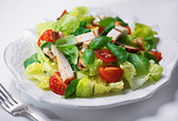 Fototapeta  - grilled chicken salad with fresh vegetables and basil