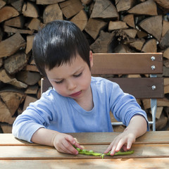 Child eating green peas