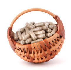 Wall Mural - Herbal drug capsules in wicker basket. Alternative medicine conc