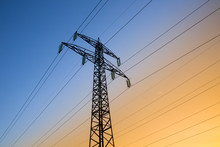 Electric Power Lines Against Blue And Yellow Sky