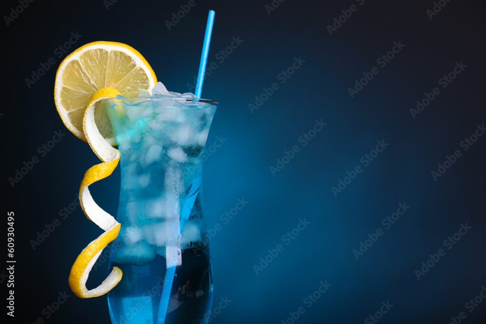 Glass of cocktail on table on dark blue background