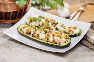 Canvas Print - Zucchini stuffed with couscous vegetable salad on wooden table