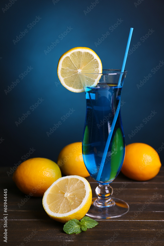 Glass of cocktail on table on dark blue background