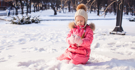 Wall Mural - Adorable little girl outdoor in the park on a winter day