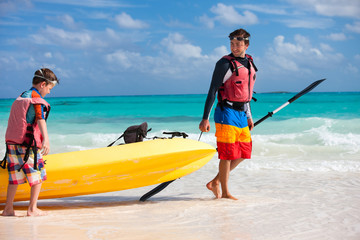 Canvas Print - Father and son pulling kayak