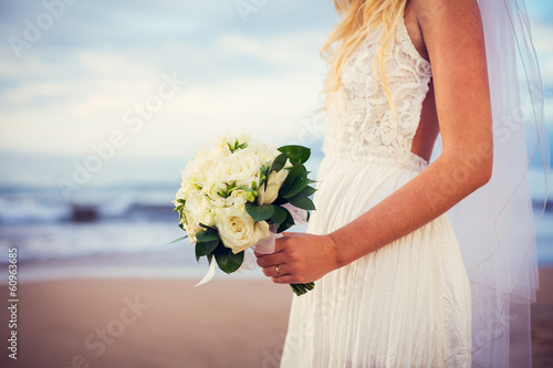 Fotografie, Obraz beautiful bride standing by the beach at sunset
