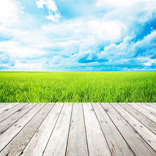 Wooden Pier With Grass Field And Blue Sky Background