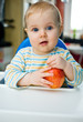 Baby with an apple at home;