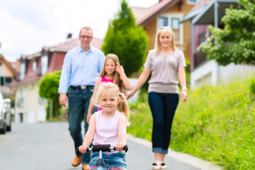 Familie macht Spaziergang durch Wohngebiet