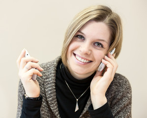 Happy woman calling with two mobile phones