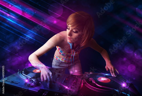 Plakat na papierze fotorealistycznym Młody dj grający na gramofonach z kolorowymi efektami świetlnymi