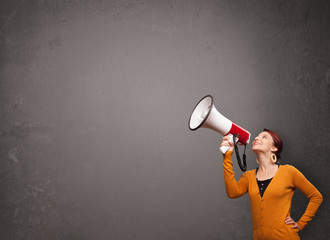 Girl shouting into megaphone on copy space background