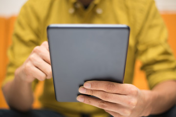 Close-up image of a man using a digital tablet