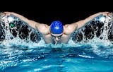Fototapeta Na sufit - Muscular young man in blue cap in swimming pool