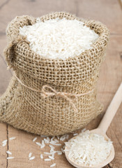 Wall Mural - rice in a burlap bag on wooden surface