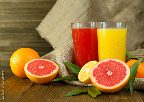 Naklejka na kafelki Lots ripe citrus with juice on wooden background