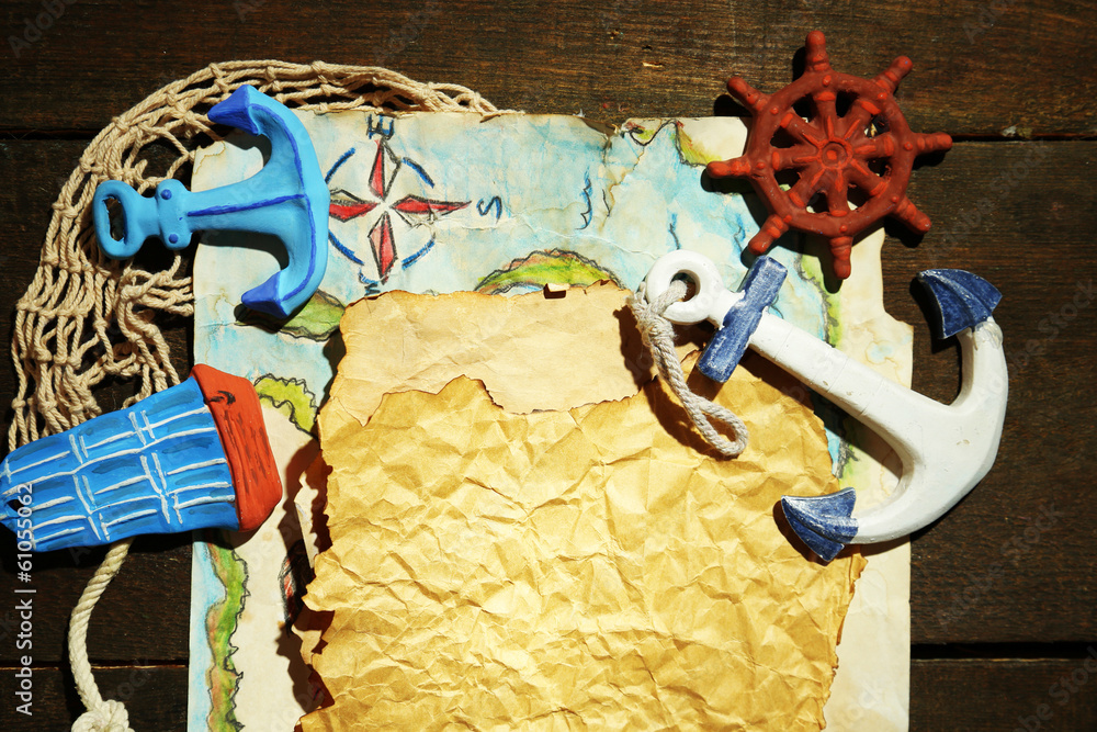 Old paper with sea accessories, isolated on wooden background