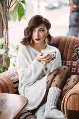 Young girl drinking coffee in a trendy cafe