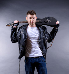 Wall Mural - Young musician with guitar on dark color background