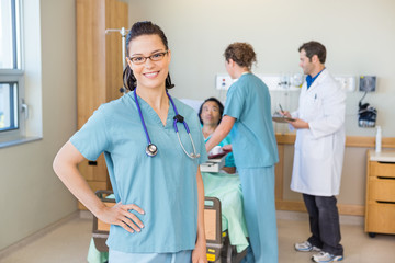 Wall Mural - Nurse With Hand On Hip Against Patient And Medical Team